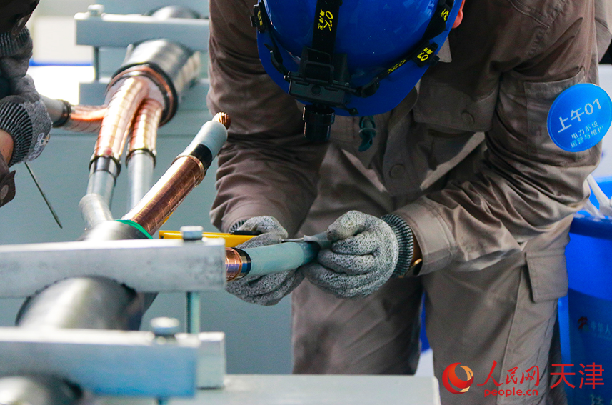 選手們?cè)谂ν瓿芍虚g接頭的制作。人民網(wǎng)記者 唐心怡攝